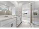 A stylish bathroom showcasing double sinks, quartz countertops, and a modern, glass-enclosed shower at 16517 W 92Nd Pl, Arvada, CO 80007