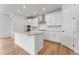 Bright, modern kitchen featuring white cabinets, a kitchen island, and stainless steel appliances at 16517 W 92Nd Pl, Arvada, CO 80007