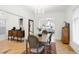 Dining room features hardwood floors, large chandelier, and open access to the living room at 3147 Vallejo St, Denver, CO 80211