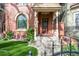 Inviting front porch features a cozy seating area and beautifully landscaped garden with vibrant flowers and well-kept lawn at 3147 Vallejo St, Denver, CO 80211