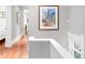 Well-lit hallway with hardwood floors, artwork, and access to multiple rooms at 3147 Vallejo St, Denver, CO 80211