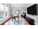 Bright home office with a modern desk, patterned rug, and comfortable seating area with mounted TV at 3147 Vallejo St, Denver, CO 80211