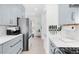 Galley kitchen with bright white counters and shaker cabinets looks into a sun-filled hallway at 3147 Vallejo St, Denver, CO 80211