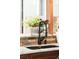 Modern kitchen sink with granite countertops, rustic brick backsplash and window with garden view at 3147 Vallejo St, Denver, CO 80211