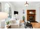 Sunlit living room features a fireplace, hardwood floors, arched window, and neutral decor for a cozy atmosphere at 3147 Vallejo St, Denver, CO 80211