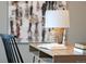 Close-up of the light wood desk with books and lamp on it, paired with artwork at 3147 Vallejo St, Denver, CO 80211