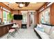 Cozy sunroom with brick accents features a comfortable sitting area and kitchenette with wood ceiling at 3147 Vallejo St, Denver, CO 80211