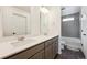 Bathroom featuring double sink vanity, modern fixtures, hexagon tile floor, and a shower-tub combination at 10224 Worchester St, Commerce City, CO 80022