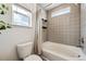 Modern bathroom featuring tiled walls and floors, a shower and bathtub combination, and a window at 10224 Worchester St, Commerce City, CO 80022