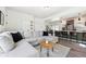 Open-concept living room with a gray sectional sofa, hardwood floors, and a view into the modern kitchen at 10224 Worchester St, Commerce City, CO 80022