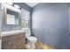 Charming powder room with blue walls, modern sink, vanity and window at 1522 Chimney Peak Dr, Castle Rock, CO 80109