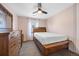 Bedroom features a wood bed frame, wood dresser, neutral carpet, and a ceiling fan at 1522 Chimney Peak Dr, Castle Rock, CO 80109