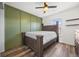 Bedroom features a wooden bed frame, a unique green accent wall, and a ceiling fan at 1522 Chimney Peak Dr, Castle Rock, CO 80109