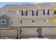 Townhome exterior features neutral siding, black shutters, and attached garages at 1522 Chimney Peak Dr, Castle Rock, CO 80109