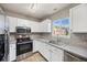 Bright kitchen features white cabinets, stainless steel appliances, and stylish tile backsplash at 1522 Chimney Peak Dr, Castle Rock, CO 80109