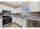 Bright kitchen features white cabinets, stainless steel appliances, and stylish tile backsplash at 1522 Chimney Peak Dr, Castle Rock, CO 80109