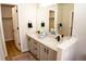 Bright bathroom features a double sink vanity, granite counters, and opens to a closet at 6845 S Webster St # E, Littleton, CO 80128