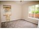 Sun-lit bedroom with neutral carpet, ceiling fan, and ample natural light from the window at 6845 S Webster St # E, Littleton, CO 80128