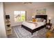 Cozy bedroom featuring a queen size bed with decorative pillows, a ceiling fan, and a bright window at 6845 S Webster St # E, Littleton, CO 80128