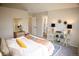 Spacious bedroom featuring a well-lit doorway to bathroom, vaulted ceilings and neutral colors at 6845 S Webster St # E, Littleton, CO 80128