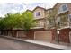 Exterior of townhome featuring garages, brick facade, and beautiful tree lined street at 6845 S Webster St # E, Littleton, CO 80128