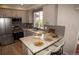 Modern kitchen featuring stainless steel appliances, granite countertops, and bar seating at 6845 S Webster St # E, Littleton, CO 80128