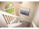 Carpeted staircase leading upstairs has large window for natural light and modern art at 6845 S Webster St # E, Littleton, CO 80128