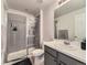 Well-lit bathroom featuring a glass-enclosed shower with gray tiling, a sink, and a white toilet at 917 White Leaf Cir, Castle Rock, CO 80108