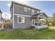 Back exterior view featuring a covered patio, well-maintained lawn, and a two-story home with gray siding at 917 White Leaf Cir, Castle Rock, CO 80108