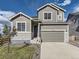 Charming two-story home with gray siding, stone accents, and a well-manicured front lawn at 917 White Leaf Cir, Castle Rock, CO 80108