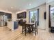 A modern kitchen with dark cabinets, an island, and stainless steel appliances next to a dining area at 917 White Leaf Cir, Castle Rock, CO 80108