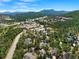 Scenic aerial view of Evergreen neighborhood with lush trees and distant mountain range at 31042 Wildwoods, Evergreen, CO 80439