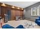 Entertainment space with wood-panel accent wall, glass table, and blue seating at 31042 Wildwoods, Evergreen, CO 80439
