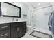 Bathroom with a walk-in shower with glass door and modern vanity with large mirror at 31042 Wildwoods, Evergreen, CO 80439