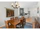 Open dining room with wood table, chandelier, and tapestry adjacent to living room with fireplace at 31042 Wildwoods, Evergreen, CO 80439