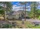 A charming single-story home featuring a well-maintained lawn, mature trees, and a two-car garage at 31042 Wildwoods, Evergreen, CO 80439
