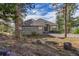 Beautiful home featuring stone accents, a well-manicured lawn, and mature trees at 31042 Wildwoods, Evergreen, CO 80439