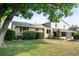 Spacious backyard features lush lawn, mature trees, and a charming two-story home with screened in porch at 6463 S Vance St, Littleton, CO 80123