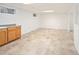 Tile floor basement with cabinets for storage, and bright lighting at 6463 S Vance St, Littleton, CO 80123