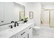 Clean bathroom featuring marble countertops, modern black fixtures, framed mirror, and shower with gold trim at 6463 S Vance St, Littleton, CO 80123