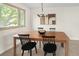 Elegant dining room boasts a wooden table and black chairs near a sunlit window, complemented by modern decor at 6463 S Vance St, Littleton, CO 80123