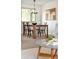 A dining room displays a wooden table and black chairs beneath a modern chandelier, complimented by beige walls at 6463 S Vance St, Littleton, CO 80123
