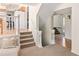 Inviting entryway showcasing hardwood floors, carpeted stairs, and white railings at 6463 S Vance St, Littleton, CO 80123
