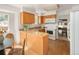 Well-lit kitchen with wood cabinets, granite countertops, modern appliances, and an adjacent dining area at 6463 S Vance St, Littleton, CO 80123