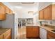 Spacious kitchen with oak cabinets, granite countertops, and modern appliances leading into dining and living areas at 6463 S Vance St, Littleton, CO 80123