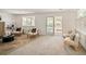 Bright living room with a brick fireplace, neutral carpet, and a sliding glass door to outside at 6463 S Vance St, Littleton, CO 80123