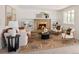 Inviting living room with a brick fireplace, built-in shelves, neutral tones, and lots of natural light at 6463 S Vance St, Littleton, CO 80123