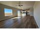 Open-concept living room featuring hardwood floors, a ceiling fan, and large windows at 48255 Shetland Dr, Bennett, CO 80102