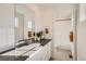 Neutral bathroom featuring a modern vanity, a decorative mirror, and a shower behind an open doorway at 907 W Beverly St, Elizabeth, CO 80107