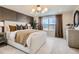 Elegant bedroom featuring a large window, paneled accent wall, soft bedding, and modern lighting at 907 W Beverly St, Elizabeth, CO 80107